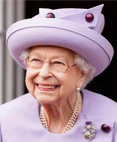 an older woman wearing a purple hat and pearls