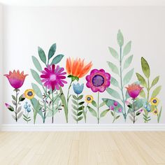 an empty room with flowers painted on the wall and wood flooring in front of it