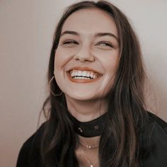 a woman with long hair smiling and wearing a choker on top of her neck