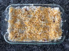 a casserole with cheese and other toppings in a glass dish on a counter