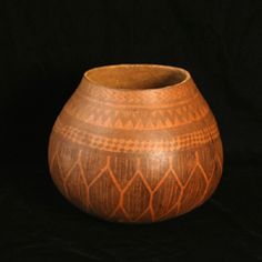 a brown vase sitting on top of a black table