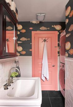 a bathroom with a sink, mirror and pink door