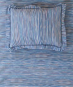 a blue and white striped pillow on a bed