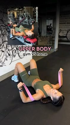 a woman laying on top of a gym floor holding a pink belt in her hand