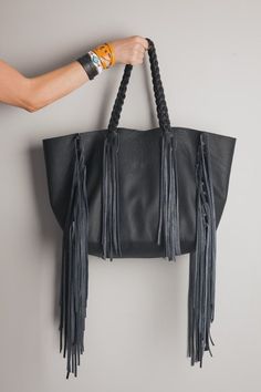 A fringe tote that completes the perfect boho chic look. The Cleo Fringe Tote is the perfect answer for a carryall that is packed with style. We love it with jeans and boots in the cooler seasons and flowy maxi dresses in the summer. The Cleo Fringe features a detachable pouch created from the same Genuine Italian leather as the outside that can hold your keys and cell phone and lip gloss and hand braided straps for the perfect touch of detail. Made from 100% Genuine Italian leather. Our bags ar Handmade Leather Tote, Fringe Tote Bag, Large Hobo Bag, Flowy Maxi Dress, Braided Strap, Large Bag, Black Bag, Handmade Leather, Hobo Bag