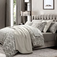 a bed with white sheets and pillows in a bedroom