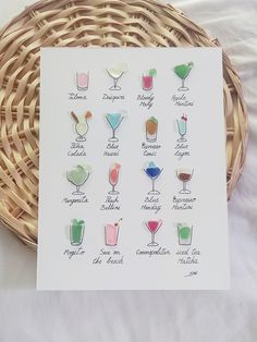 a card with different types of cocktails on it next to a wicker basket