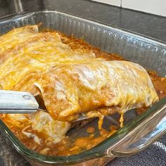 a glass casserole dish filled with meat and cheese covered in gravy