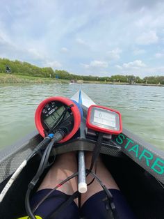 someone is sitting in a boat with their feet on the steering wheel and there are two electronic devices attached to it