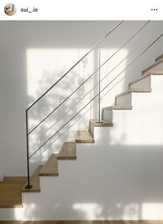 there is a stair case in the room with white walls and wood flooring on the stairs