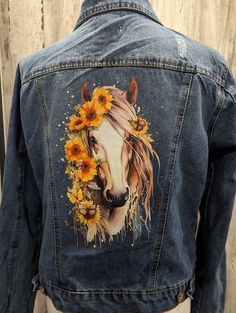 a denim jacket with a horse and sunflowers painted on the back of it