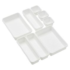 four white plastic trays with holes on the bottom and one is filled with compartments