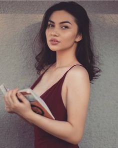 a woman in a red dress holding a book