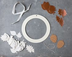 paper leaves, scissors and other crafting supplies laid out on a table with some cut outs