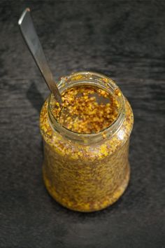 a jar filled with mustard sitting on top of a table