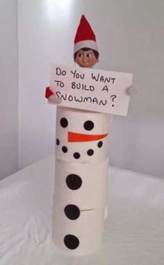 a snowman made out of toilet paper with a sign on it that says do you want to build a snowman?