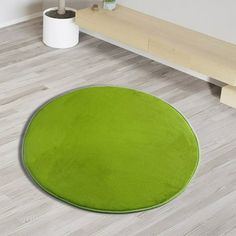 a bright green rug is on the floor next to a wooden bench