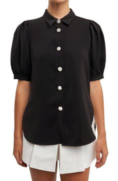 Elbow-length puff sleeves frame this woven blouse featuring a stone-embellished button-up closure and a sleek point collar. Point collar Elbow-length sleeves 100% polyester Hand wash, dry flat Imported