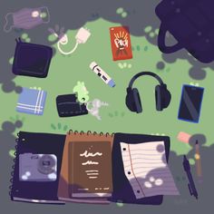 various items are spread out on the ground, including an open notebook and headphones