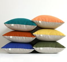 four different colored pillows stacked on top of each other