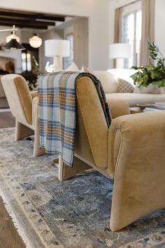 a living room with couches, chairs and rugs on top of the floor