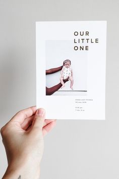 a hand holding up a card with an image of a baby