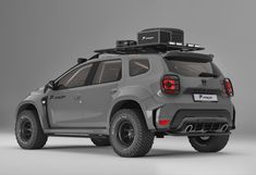 the rear end of a grey four - door suv with luggage strapped to it's roof