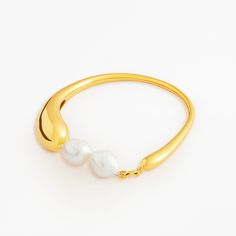 Aura bracelet in 18K gold vermeil with freshwater pearls. Circumference: 8" Diameter: 2.5" to 2.75" Pearls strung with silk thread Nickel free 2.5 microns of 18K gold vermeil Base metal is recycled sterling silver Handcrafted in high polish Every pearl is unique in shape and color MYW04GV214PL Gold Pearl Bracelet With Oyster Detail, Modern Gold Pearl Bracelet, Gold Bangle Bracelet With Pearl Drop, Gold Pearl Charm Bangle Bracelet, Gold Pearl Drop Bangle Jewelry, Gold Baroque Pearl Bracelet With Pendant, Gold Pearl Drop Bangle, Modern Gold Pearl Bracelets, Yellow Gold Baroque Pearl Chain Bracelet