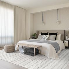 a bedroom with a large bed and white curtains