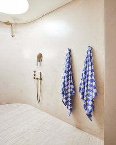 two blue and white towels hanging on the wall