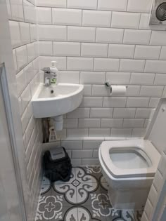 a white toilet sitting next to a sink in a bathroom