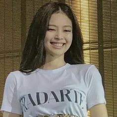 a woman with long hair wearing a t - shirt and holding a plate of food