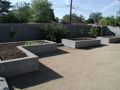 several cement planters are lined up on the concrete floor in front of a fence