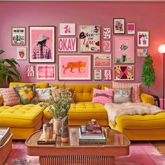 a living room filled with yellow couches and pictures on the wall above them,