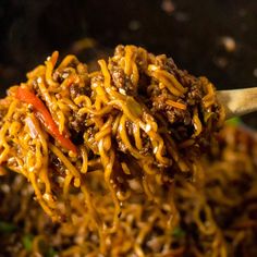 a spoon full of noodles with meat and vegetables