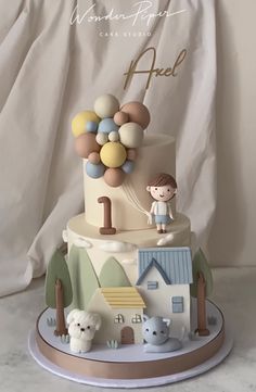 a cake decorated with animals and balloons for a first birthday party or baby's first birthday