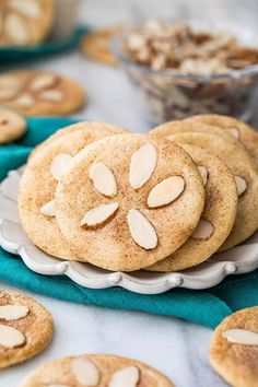 cookies with almonds are on a white plate