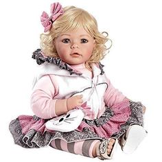 a baby doll sitting on the ground with her hands in her pockets, wearing a pink and white outfit