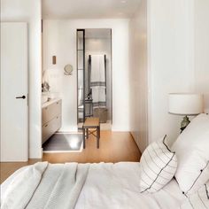 a bedroom with white walls and wooden floors