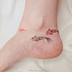 a woman's foot with two koi fish on it