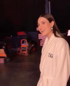 a woman in a bathrobe smiles at the camera