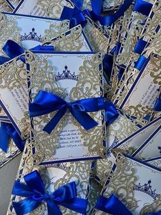 royal blue and gold wedding cards with matching ribbon bows are laid out on top of each other