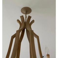 a wooden chandelier hanging from the ceiling with two candles in front of it