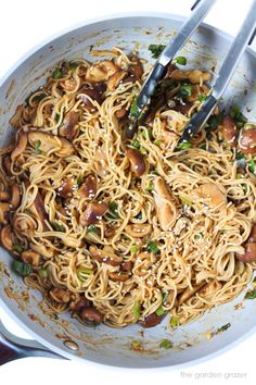 noodles with mushrooms and green onions in a white bowl