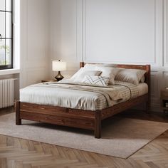 a bed sitting on top of a wooden floor next to a window in a bedroom