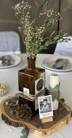 there is a vase with flowers in it and pictures on the table next to it