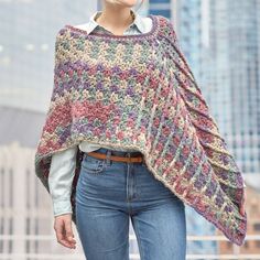 a woman wearing a crocheted shawl in the city