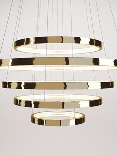 a modern chandelier with circular lights hanging from it's sides and round rings on the ceiling