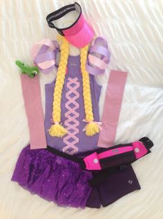 a costume made out of clothes and hair on top of a white bed with purple ruffles