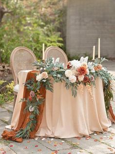 a table with flowers and candles on it is set up in the middle of an outdoor area